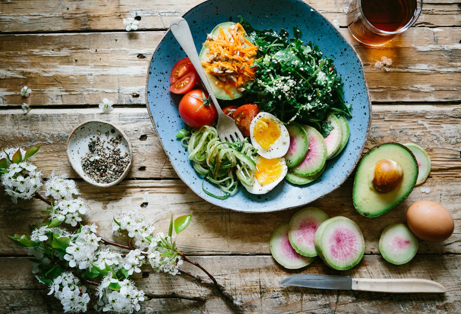 Abacates abertos e alimentos frescos sobre mesa rústica